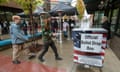 two people walk towards ballot drop box on sidewalk