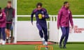 Jack Grealish jumps over orange cones during training.