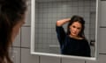 The actor Demi Moore looks into a mirror in a bathroom.