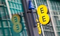 the EE sign reflected in shop glass