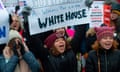 a woman holds sign next to two women