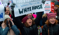 a woman holds sign next to two women