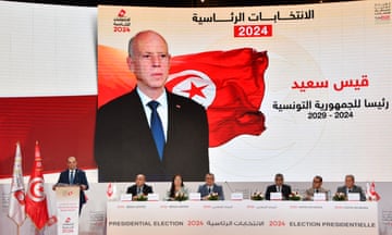 The president of the Independent High Authority for Elections in Tunisia in front of a huge picture of Kais Saied