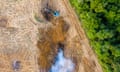 Aerial image of a bulldozer removing trees. Lush forests are on one side and barren earth on the other