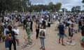 Groups of people stand near pictures of people killed in the 7 October attacks