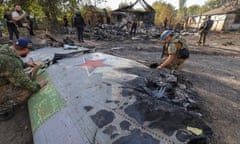 Ukrainian servicemen inspect the remains of a Russian aerial vehicle in a residential area of Kostiantynivka town after Ukrainian forces said they shot it down over eastern Donetsk province on Saturday