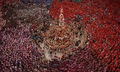 An overhead shot of a circular human tower surrounded by a wider circle of watchers