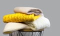 Stack of Trendy Bright illuminating Yellow and White Woolen Knitted Sweaters on Gray Background. 