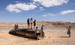 People stand on top of the remains of an Iranian missile in the Negev desert