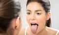 Woman sticks out tongue in mirror