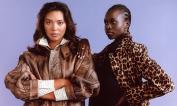 Two models, one wearing a striped shirt and a brown leather jacket, and the other wearing a black shirt and a leopard print coat, both standing in front of a lilac background