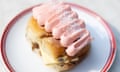 Close-up of a finger bun with pink cream cheese frosting